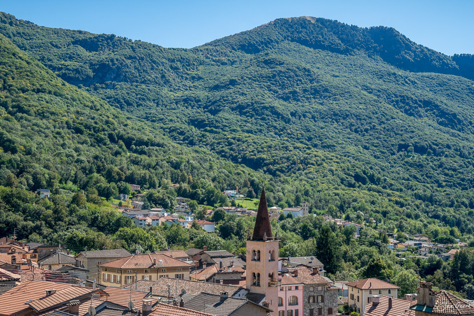 Dorfansicht mit Kirchturm in sommerlicher Berglandschaft Tessin Schweiz – Jan Geerk Fotograf Basel