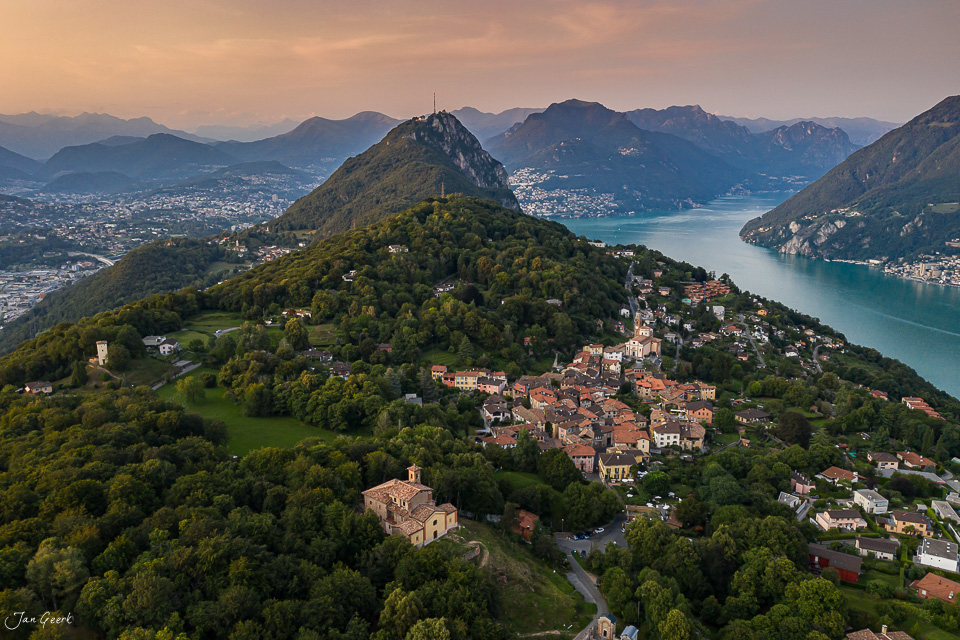 Luftaufnahme Tessin mit See, Bergen und Dorf in Morgenlicht, Südschweiz – Jan Geerk Fotograf Basel