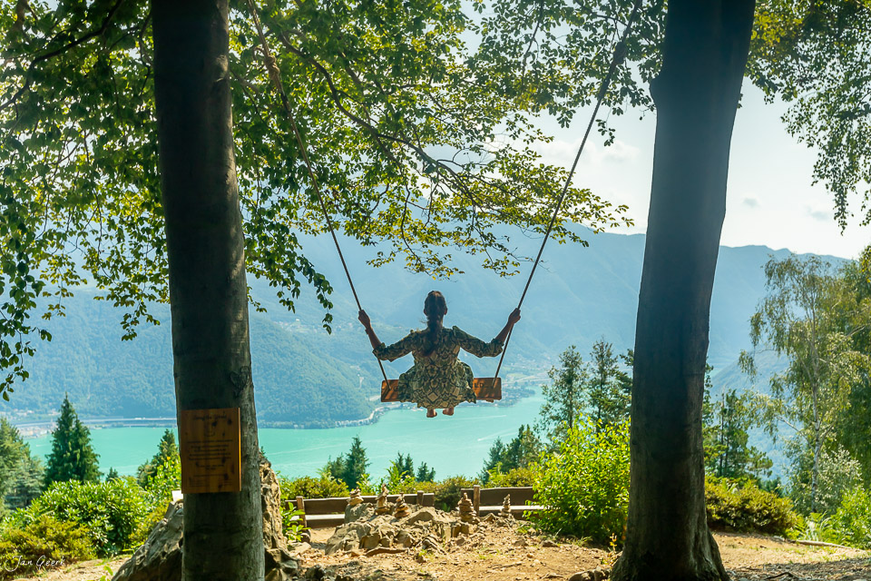 Frau auf Schaukel über türkisem See Tessin Alpen Sommer Schweiz Jan Geerk Fotograf Basel