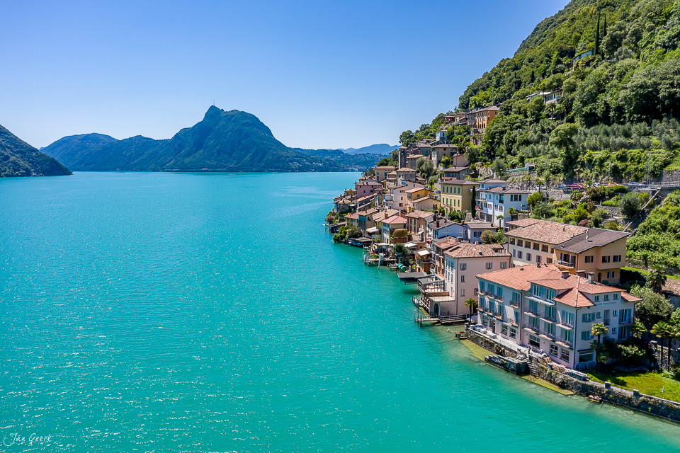 Luftaufnahme des Dorfes Gandria am türkisfarbenen Lago di Lugano unter Sommersonne, Tessin Schweiz – Jan Geerk Fotograf Basel