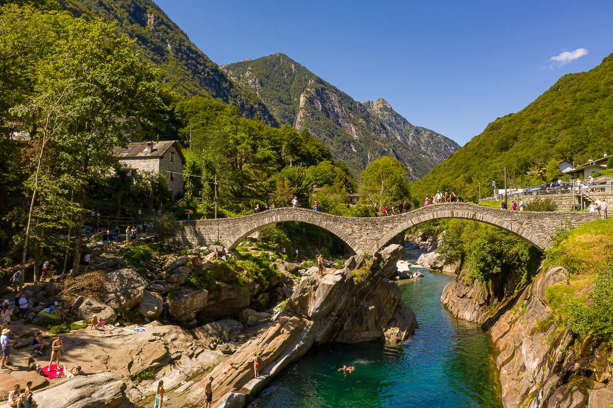 Steinbrücke über türkisfarbenem Fluss in Lavertezzo Tessin Schweiz, sonnig grüne Berge Jan Geerk Fotograf Basel