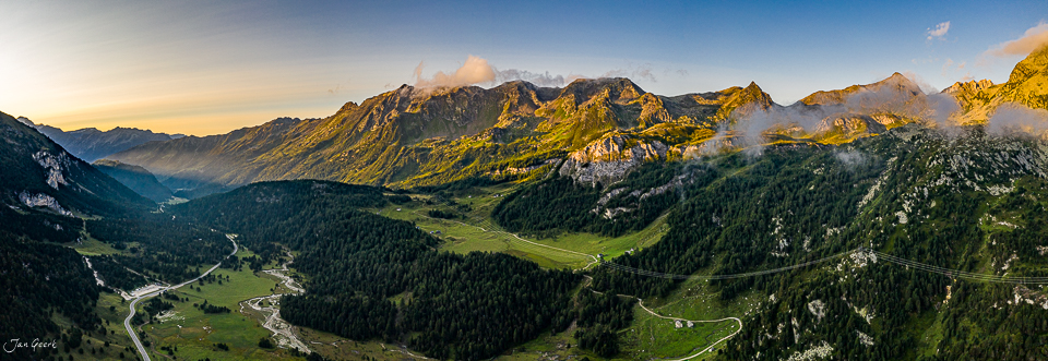 Luftaufnahme Lukmanierpass mit grünen Alpweiden, Bergketten und Nebel im goldenen Morgenlicht, Tessin Schweiz – Jan Geerk Fotograf Basel