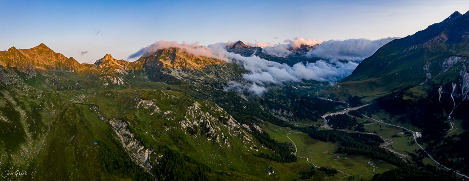 Luftaufnahme Lukmanierpass mit grünen Bergen, Nebel und Alpengipfeln im Tessin, Schweiz – Jan Geerk Fotograf Basel
