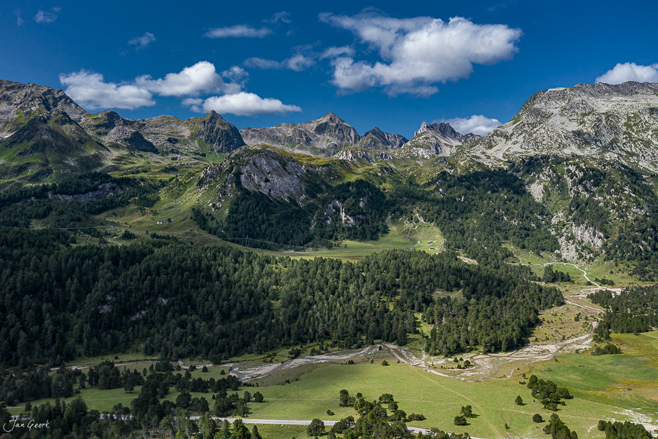 Luftaufnahme Lukmanierpass Tessin mit grünen Alpweiden, Fichtenwäldern und Bergketten unter blauem Himmel, Schweiz – Jan Geerk Fotograf Basel