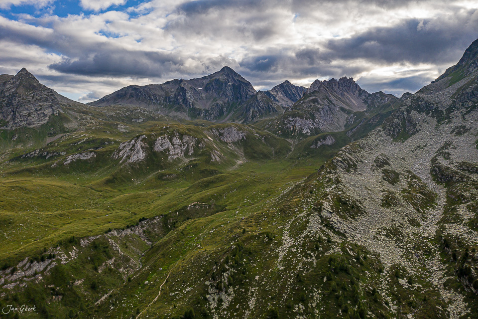 Alpenlandschaft Lukmanierpass mit grünen Wiesen und dramatischem Wolkenhimmel Tessin Schweiz – Jan Geerk Fotograf Basel