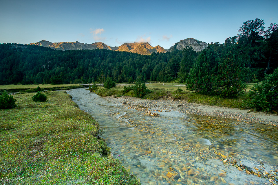 Gebirgsbach mit Alpengipfeln im Hintergrund, Sommerlichtstimmung im Tessin, Südschweiz – Jan Geerk Fotograf Basel