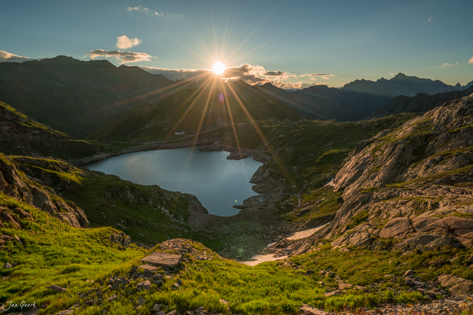 Alpensee in der Maggiatal Region mit dramatischem Sonnenstern und grüner Alpenlandschaft, Sommer, Tessin, Schweiz – Jan Geerk Fotograf Basel