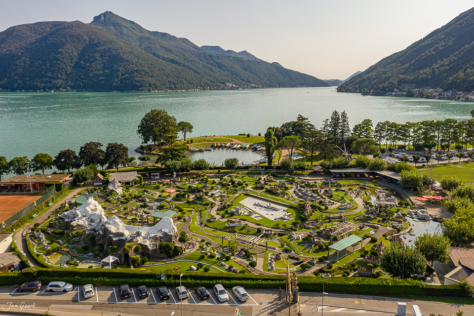 Luftaufnahme Melide mit Miniaturpark, türkisem Seewasser und bewaldeten Bergen, Sommer Tessin Schweiz – Jan Geerk Fotograf Basel