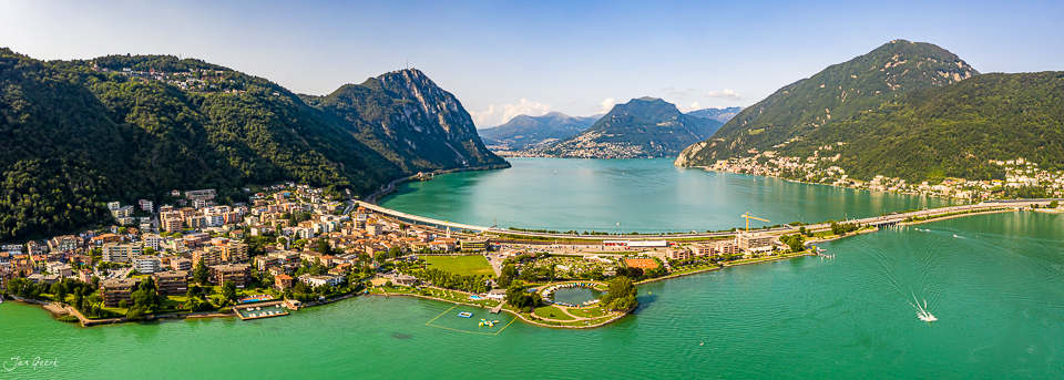 Luftaufnahme Melide mit türkisblauem See, Bergen und Siedlungen im Tessin Schweiz – Jan Geerk Fotograf Basel