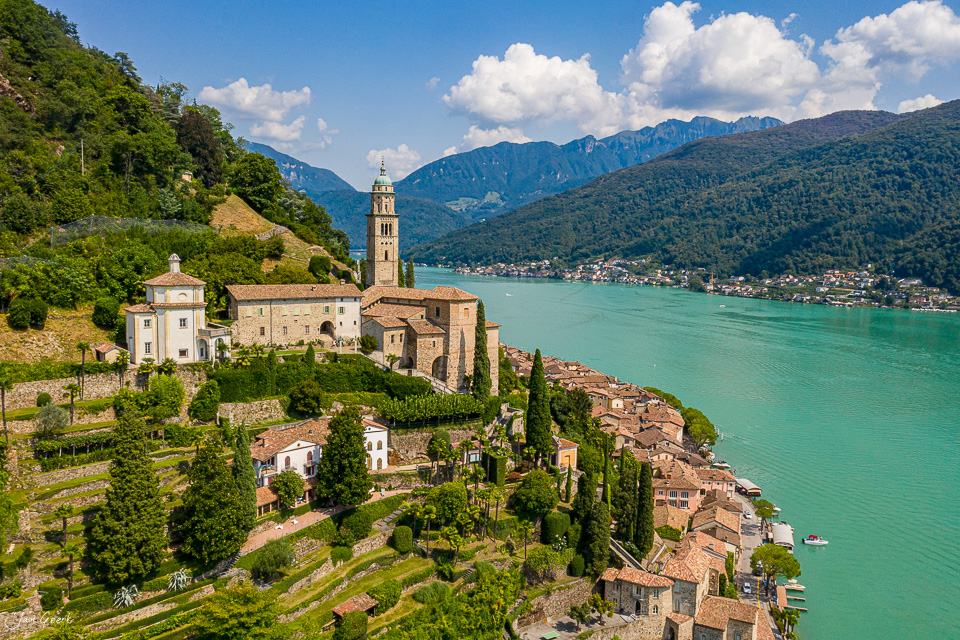Morcote Dorfkirche mit türkisem See und Alpenkulisse, Luftaufnahme bei Sonnenschein, Tessin Schweiz – Jan Geerk Fotograf Basel