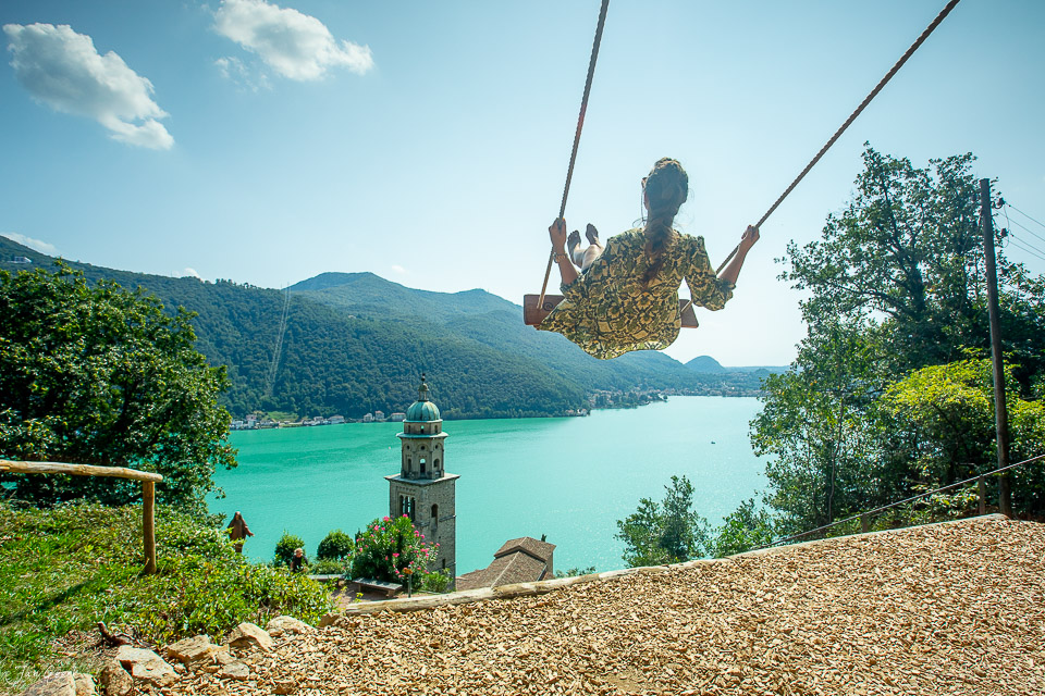 Frau auf Schaukel über türkisem See in Morcote Tessin Sommerlicht Schweiz Jan Geerk Fotograf Basel