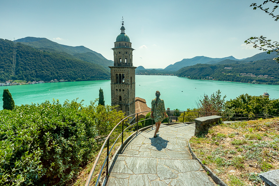 Kirchturm und türkisfarbener See in Tessin, Sommerliche Alpenszenerie in der Südschweiz – Jan Geerk Fotograf Basel