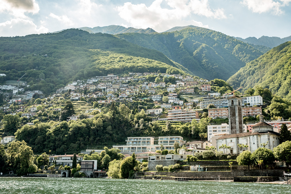 Seeufer mit Bergdorf und grünen Bergen im Frühling am Lago Maggiore Tessin Schweiz – Jan Geerk Fotograf Basel
