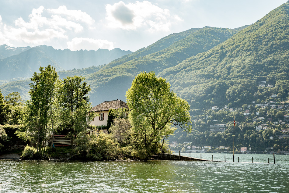 Historisches Haus am Ufer des Lago Maggiore bei Ascona, umgeben von grünen Bäumen und Bergen im Frühling, Tessin Schweiz – Jan Geerk Fotograf Basel