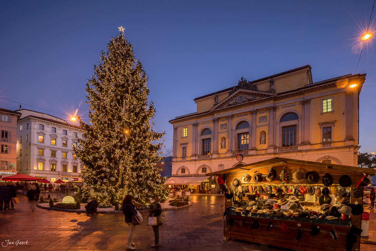 Weihnachtsmarkt mit leuchtend geschmücktem Weihnachtsbaum und historischen Gebäuden in Lugano, winterliche Festbeleuchtung, Tessin Schweiz – Jan Geerk Fotograf Basel