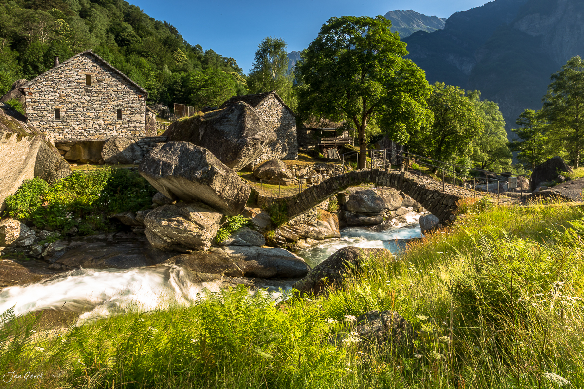 Historische Steinbrücke über Maggia Fluss Maggiatal grüne Berghänge Tessin Schweiz Jan Geerk