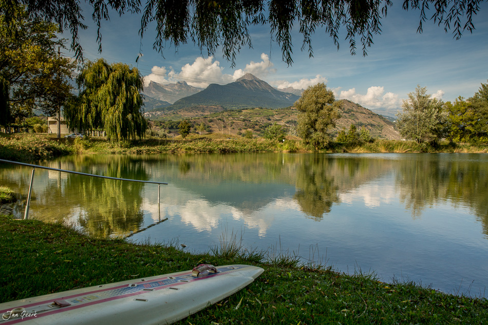 Windsurfboard am Ufer des Lac d'Aigle mit Bergpanorama im Hintergrund, Wallis Schweiz – Jan Geerk Fotograf Basel