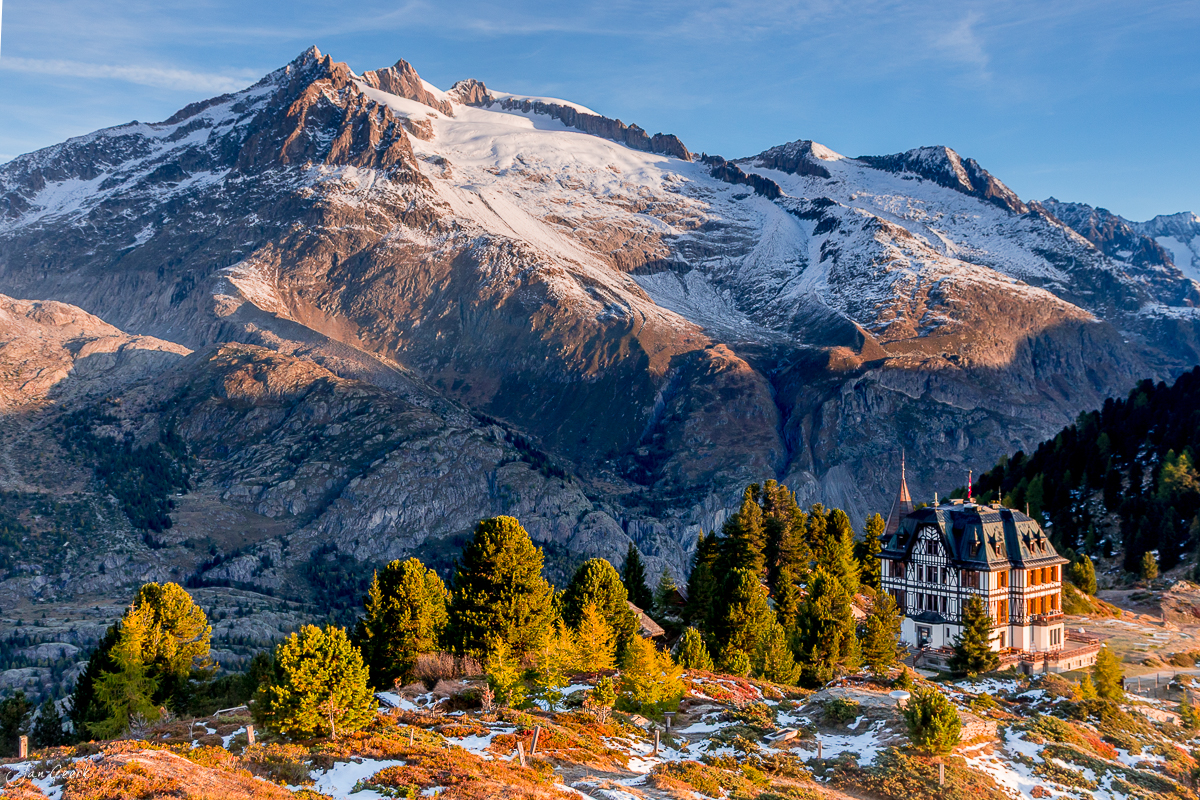 Herbstliches Aletschgebiet mit schneebedecktem Gletscher, historischem Hotel und Lärchenwald in goldenem Licht, Wallis Schweiz – Jan Geerk Fotograf Basel