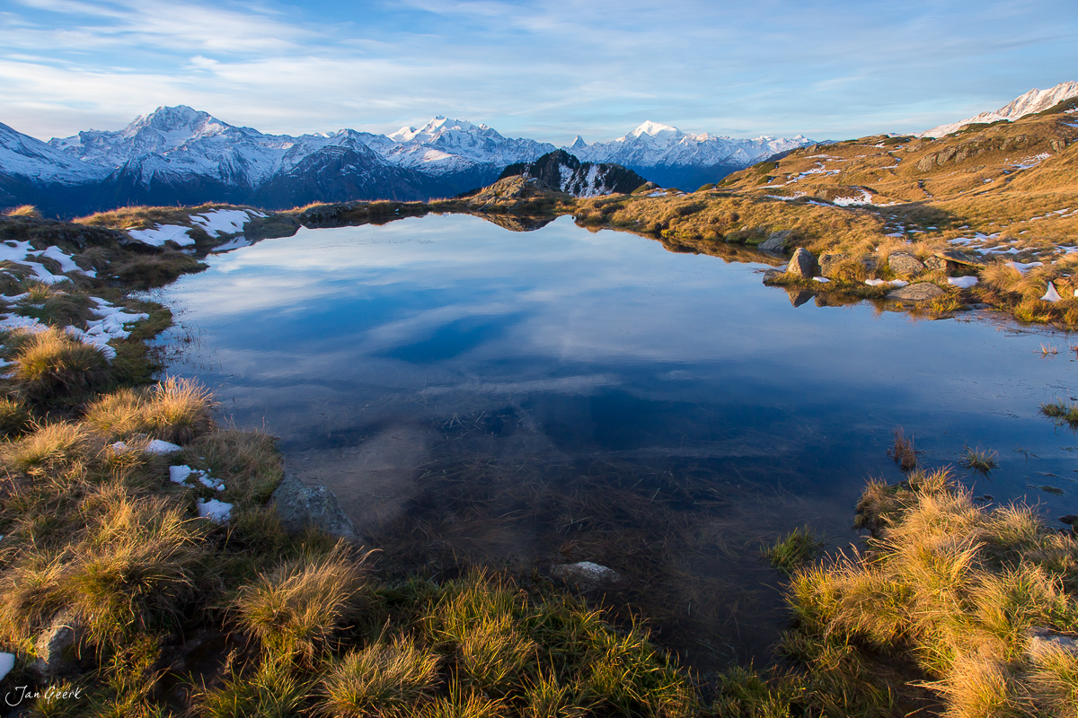 Alpiner See mit Spiegelbild der schneebedeckten Bergkette im Aletschgebiet, Herbstlicht, Wallis Schweiz – Jan Geerk Fotograf Basel