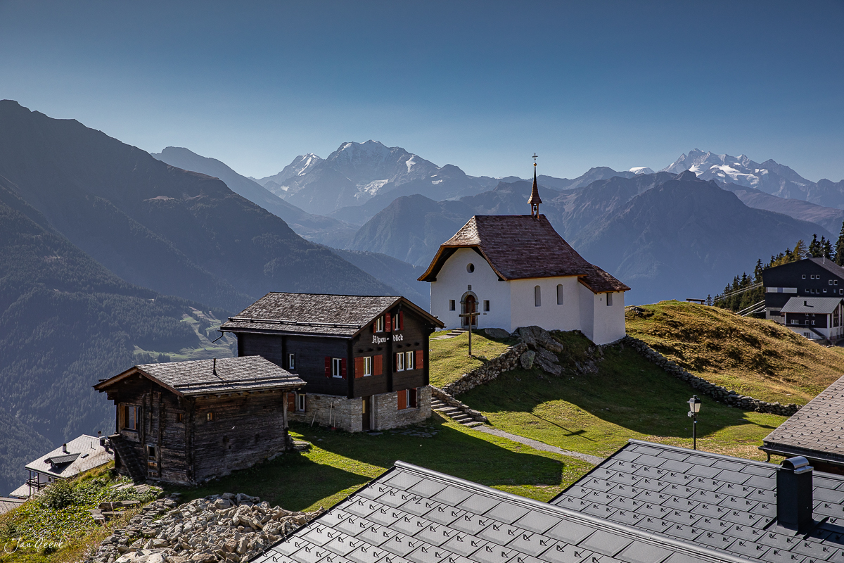 Alpines Bergdorf mit Kapelle und Almhütten auf Bettmeralp, Alpenlandschaft mit schneebedeckten Gipfeln im Herbst, Wallis Schweiz – Jan Geerk Fotograf Basel