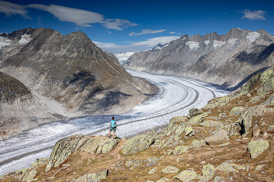 Wanderer auf Felsen blickt auf den Aletschgletscher mit Märjelensee im Herbst, Wallis Schweiz – Jan Geerk Fotograf Basel