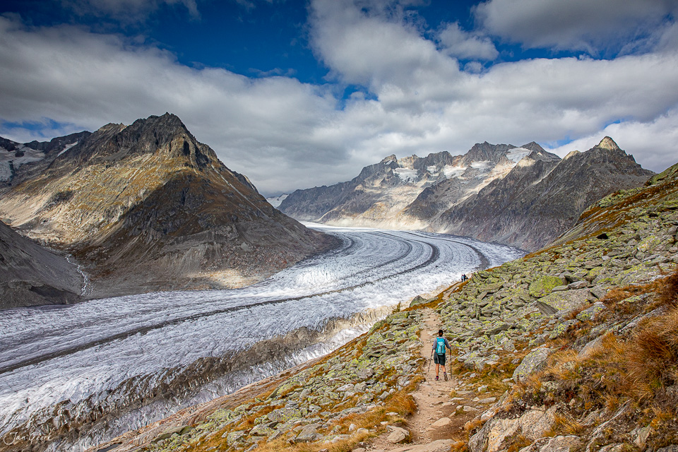 Wanderer auf Bergpfad mit Blick auf den Aletschgletscher, majestätische Gletscherlandschaft im Herbst, Wallis Schweiz – Jan Geerk Fotograf Basel