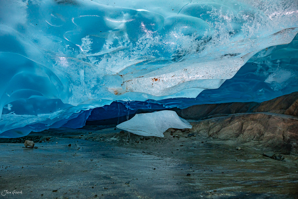Gletscherhöhle im Aletschgletscher mit leuchtend blauem Eis und herbstlicher Stimmung im Wallis, Schweiz – Jan Geerk Fotograf Basel
