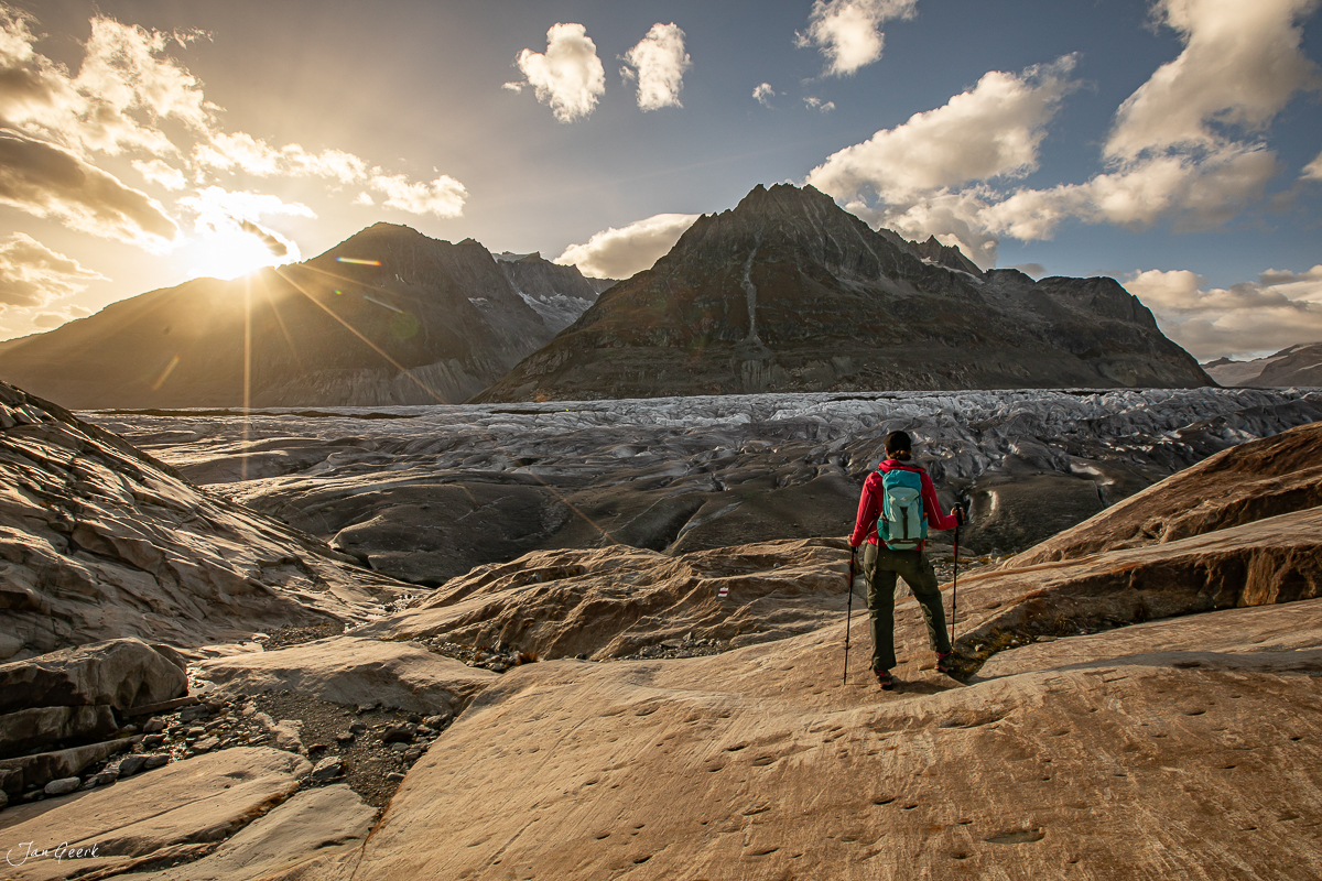 Wanderer am Aletschgletscher mit Rucksack blickt auf Gletscherlandschaft im Herbst Wallis Schweiz – Jan Geerk Fotograf Basel