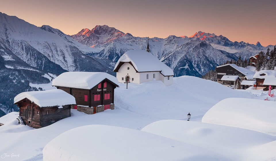Schneebedeckte Bergkapelle und Häuser Bettmeralp Wintersonnenaufgang Wallis Schweiz Jan Geerk Fotograf Basel
