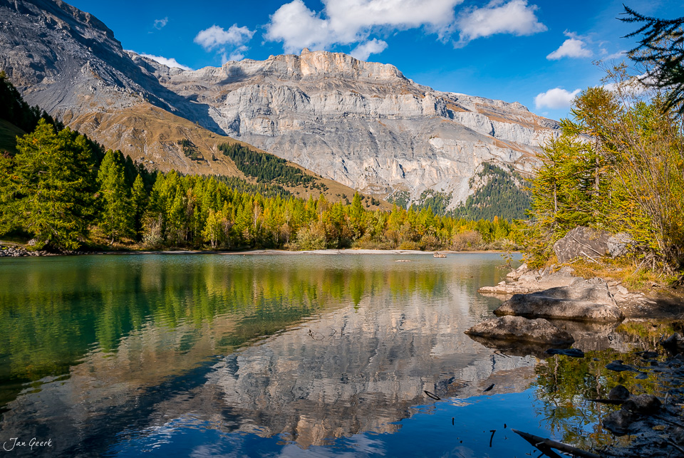 Bergsee Lac de Derborence mit herbstlicher Lärchenwälder und Felswand Wallis Schweiz Jan Geerk Fotograf Basel