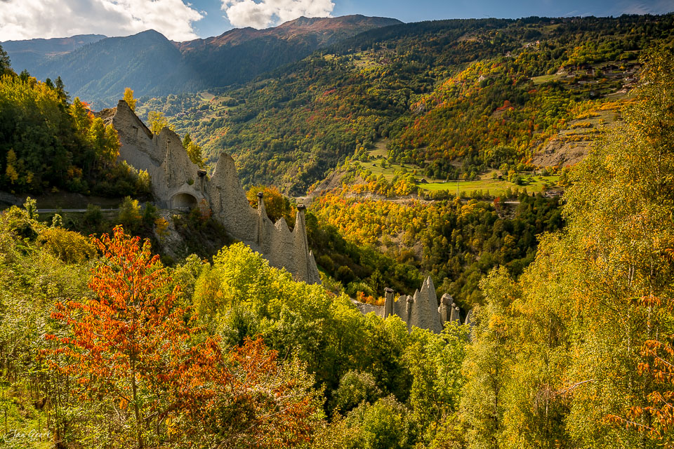 Burgruinen im Herbst im Rhonetal Wallis mit gelb gefärbtem Wald und Bergen Schweiz – Jan Geerk Fotograf Basel