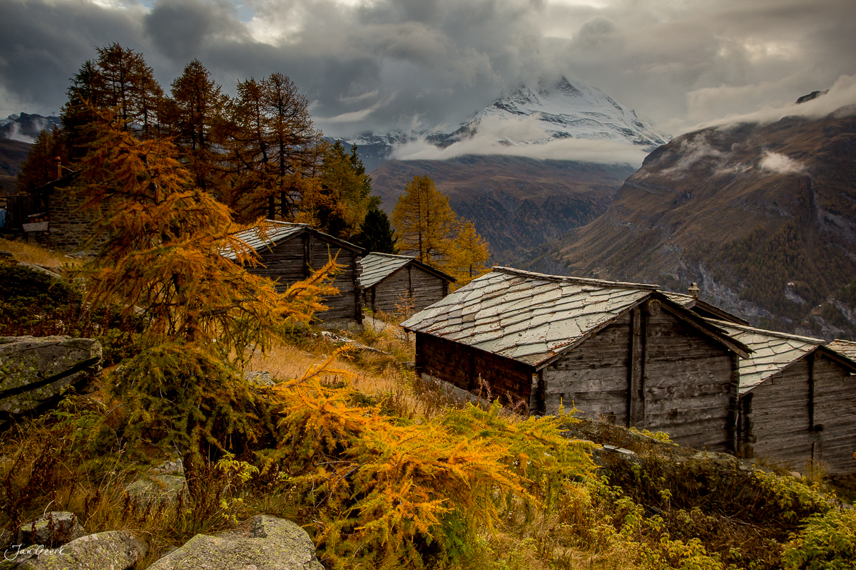 Herbstliche Alphütten am Horu mit schneebedecktem Matterhorn im Hintergrund, golden gefärbte Lärchen, Wallis Schweiz – Jan Geerk Fotograf Basel