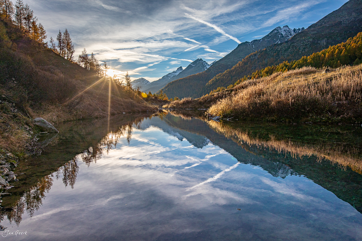 Spiegelglatter Bergsee im Lötschental mit Herbstlärchen und Bergspiegeln bei Sonnenuntergang Wallis Schweiz Jan Geerk Fotograf Basel