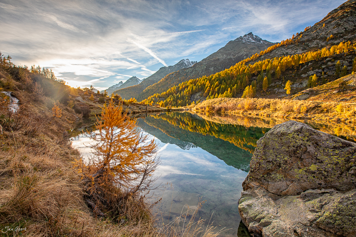 Herbstliches Bergsee-Panorama im Lötschental mit golden gefärbten Lärchen, spiegelndem Wasser und Bergpanorama Wallis Schweiz – Jan Geerk Fotograf Basel