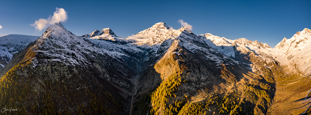 Schneebedeckte Berggipfel und goldene Lärchen im Lötschental während der Herbstzeit, Wallis, Schweiz – Jan Geerk Fotograf Basel