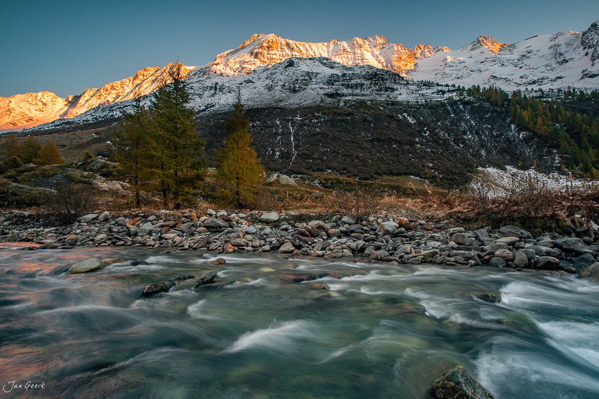 Alpiner Fluss bei Fafleralp im Herbst mit schneebedeckten Bergen und Lärchen im Lötschental Wallis Schweiz Jan Geerk Fotograf Basel