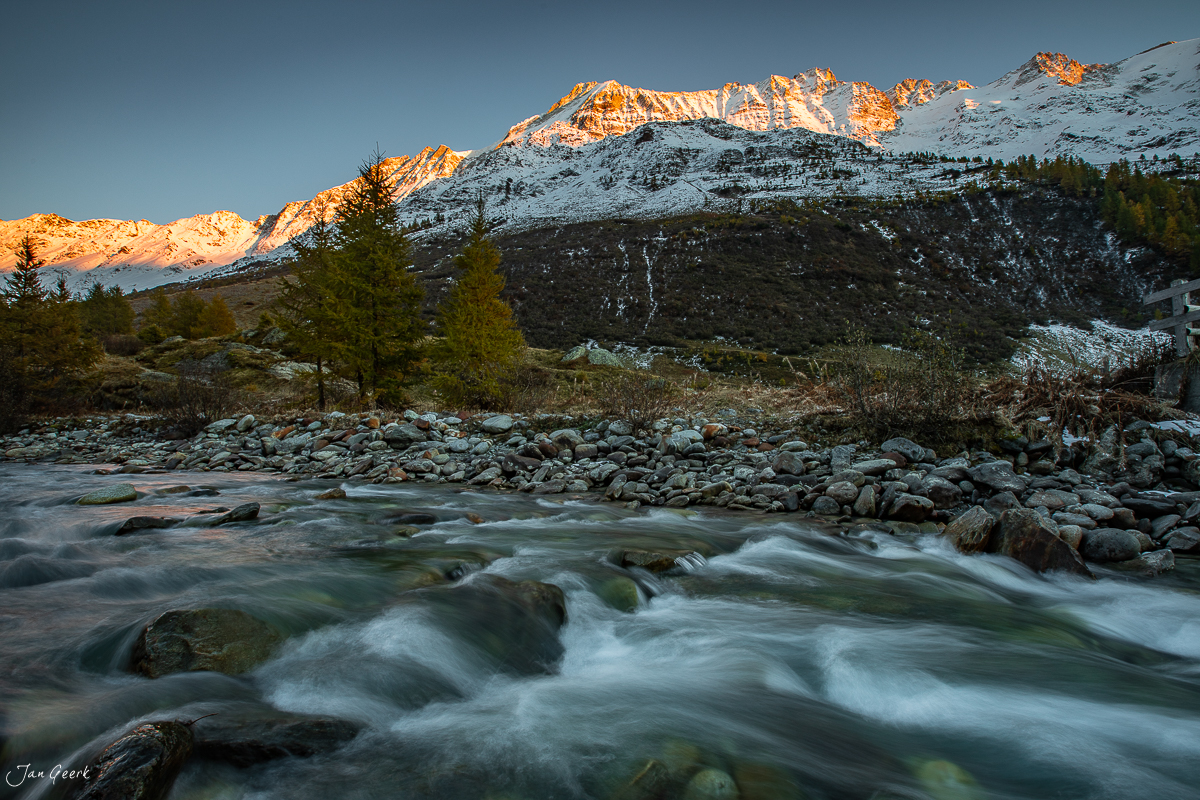 Bergfluss im Lötschental mit schneebedeckten Alpen bei Herbstlicht, Wallis Schweiz – Jan Geerk Fotograf Basel