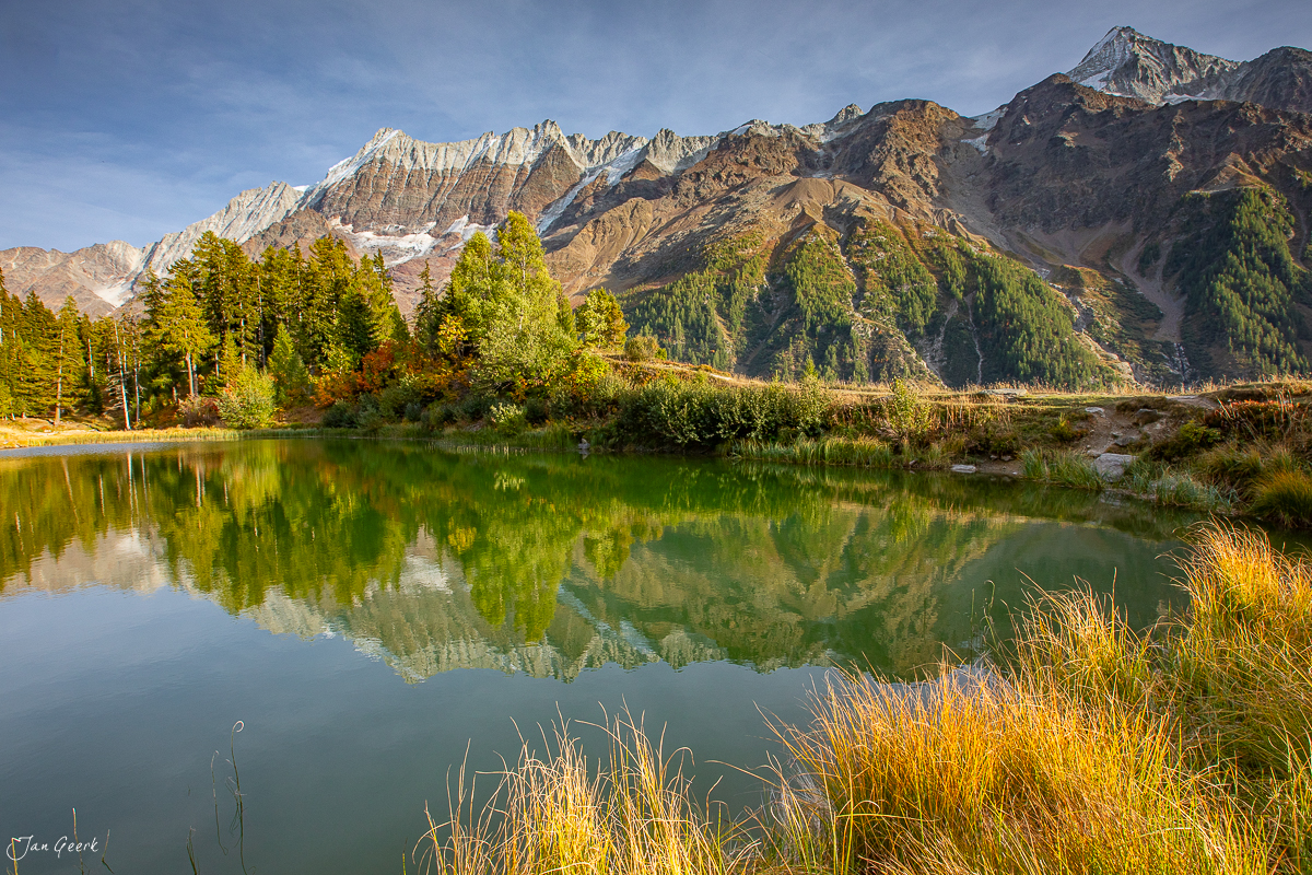Schwarzsee im Lötschental mit Spiegelung der Lärchenwälder und schneebedeckten Bietschhorn im Herbst, Wallis Schweiz – Jan Geerk Fotograf Basel