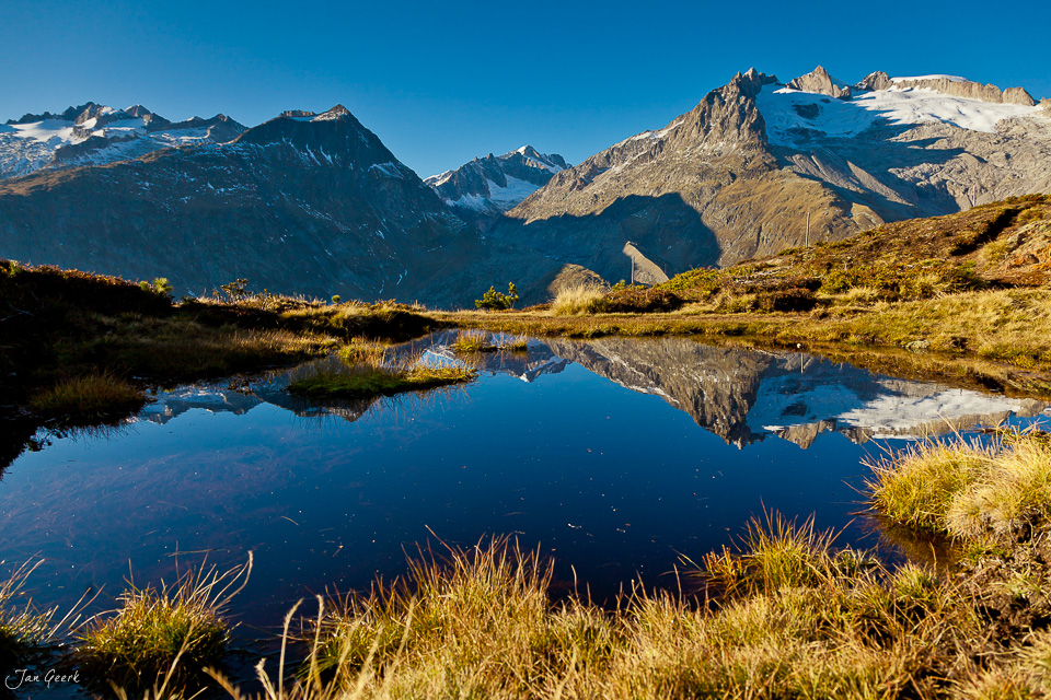Bergsee mit Spiegelung der schneebedeckten Berge im Aletschgebiet Herbststimmung Wallis Schweiz Jan Geerk Fotograf Basel