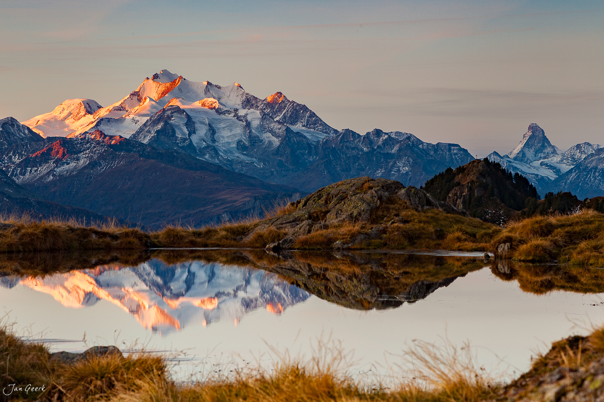 Bergsee mit Alpenglühen spiegelt schneebedeckte Gipfel Riederalp Bettmeralp Herbst Wallis Schweiz