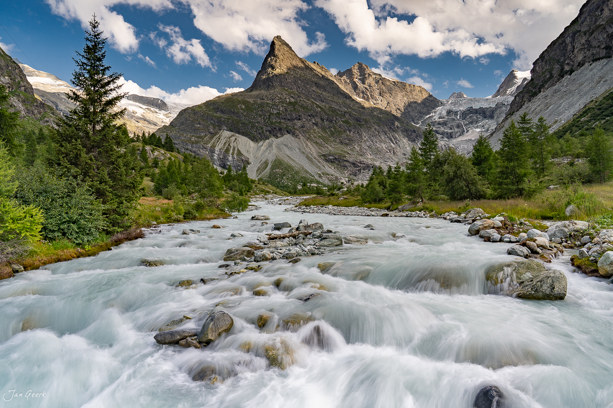 Bergfluss mit Gletscherwasser im Goms Wallis, Alpenpanorama mit schneebedeckten Gipfeln, Sommerlicht, Schweiz – Jan Geerk Fotograf Basel