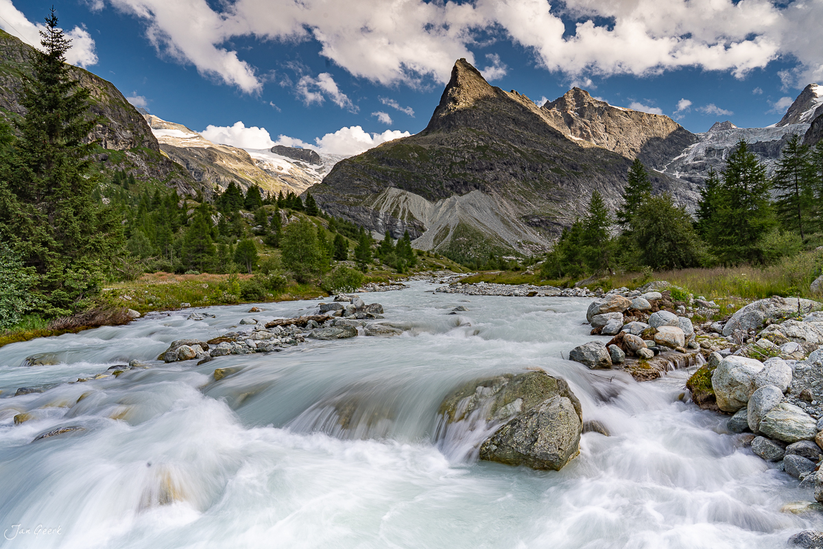 Wildwasser-Fluss mit Gebirgsbach im Goms, Wallis, sommerliches Alpenpanorama mit schneebedeckten Gletschern und Lärchenwäldern, Schweiz – Jan Geerk Fotograf Basel