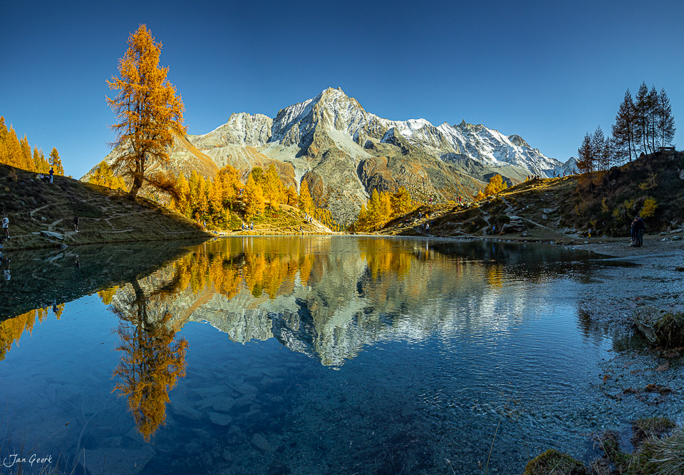 Bergsee mit Spiegelung, Herbstlärchen und schneebedecktem Berg im Wallis, Herbststimmung Schweiz – Jan Geerk Fotograf Basel