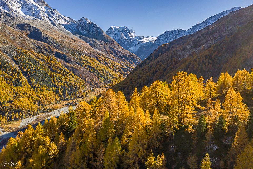 Herbstliches Tal d'Arolla mit golden gefärbten Lärchen, schneebedeckten Alpengipfeln und Fluss in der Schweiz – Jan Geerk Fotograf Basel