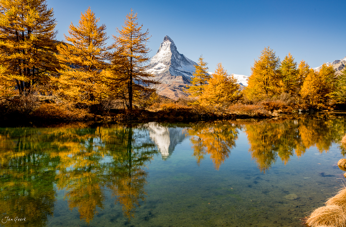 Matterhorn mit goldenen Lärchen spiegelt sich im Riffelsee, Herbststimmung im Wallis Schweiz – Jan Geerk Fotograf Basel