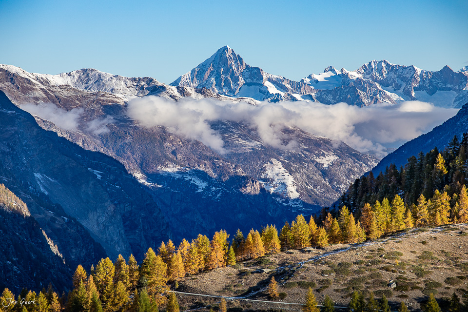 Schneebedeckte Bergkette mit goldenen Lärchen im Herbst über Zermatt, Wallis, Schweiz – Jan Geerk Fotograf Basel