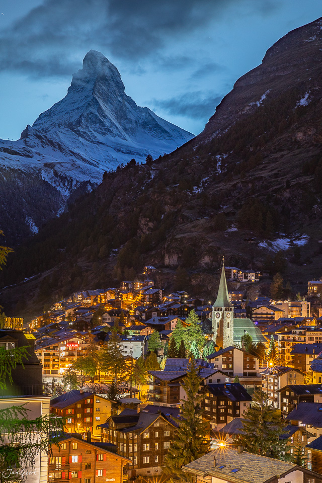 Zermatt Dorfansicht mit Matterhorn bei Dämmerung, schneebedeckte Alpen, Lärchen und Kirche, Winter Schweiz – Jan Geerk Fotograf Basel