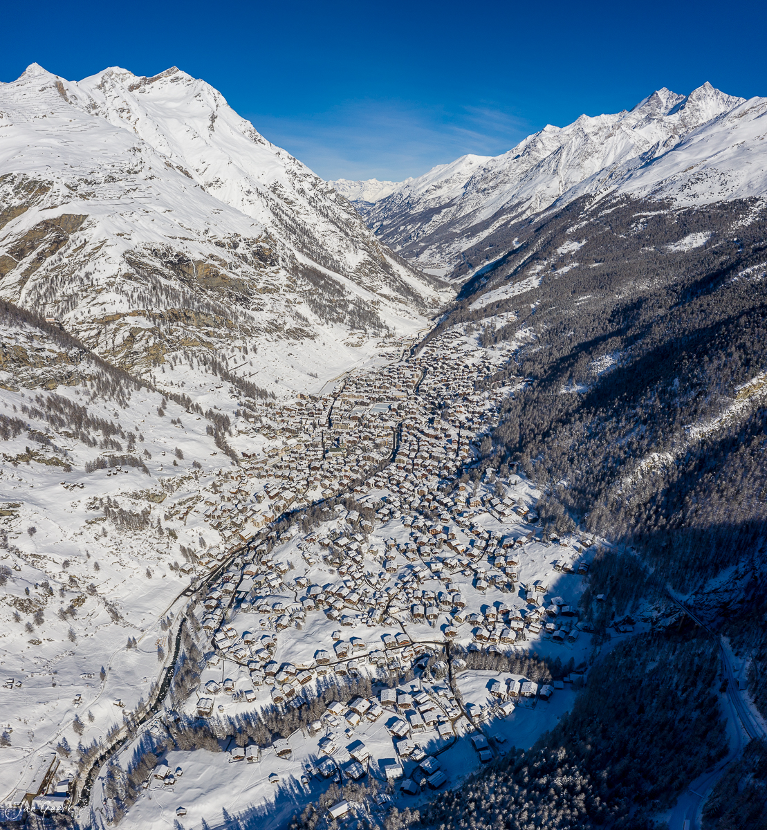 Luftaufnahme von Zermatt im Winter mit schneebedeckten Bergen und Tälern unter klarem Himmel – Jan Geerk Fotograf Basel