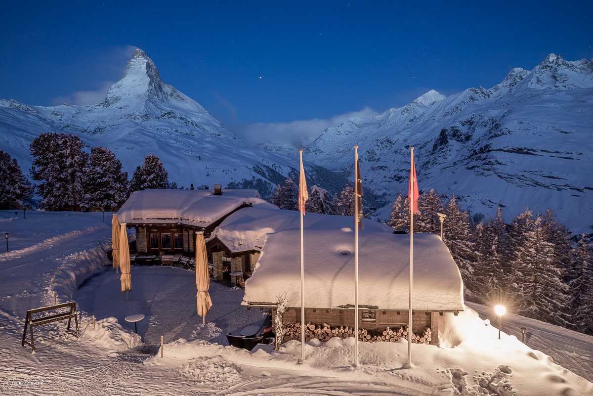 Erleuchtete Alphütten im Schnee mit Matterhorn-Blick bei Riffelalp, Wallis, Schweiz – Jan Geerk Fotograf Basel