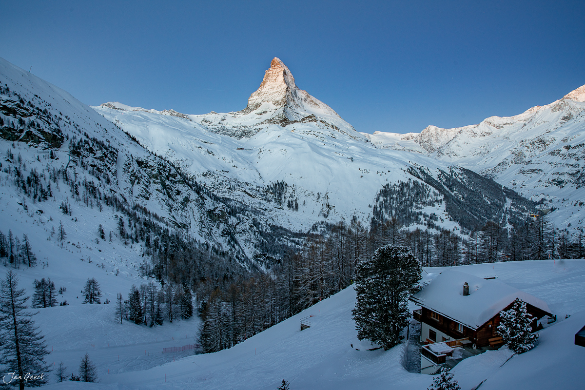 Verschneite Berglandschaft mit Matterhorn, Alpenhütte und Lärchen im Winter bei Zermatt in der Schweiz – Jan Geerk Fotograf Basel